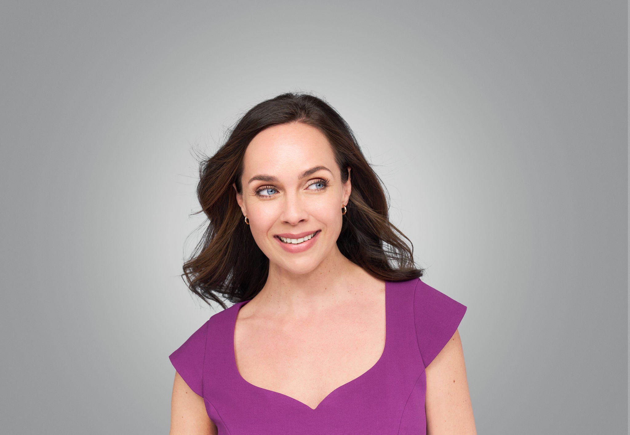 Female looks side, her fingers rest under her Cheeks.